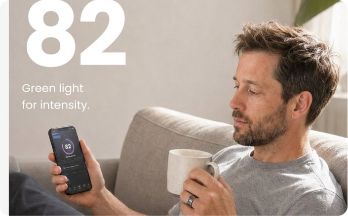 Rider on a sofa checking a recovery score of 82 in the THRIVE app